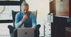 Remote worker reviews online job listing, illustrating the growing risk of AI-generated job scams and phishing threats targeting job seekers.