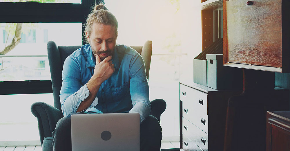 Remote worker reviews online job listing, illustrating the growing risk of AI-generated job scams and phishing threats targeting job seekers.