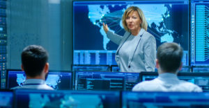 Security team reviewing global cyber threat data on multiple screens