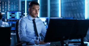 Cybersecurity professional monitoring multiple systems to manage digital certificate risks and operational resilience.
