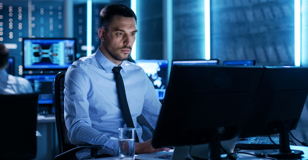 Cybersecurity professional monitoring multiple systems to manage digital certificate risks and operational resilience.