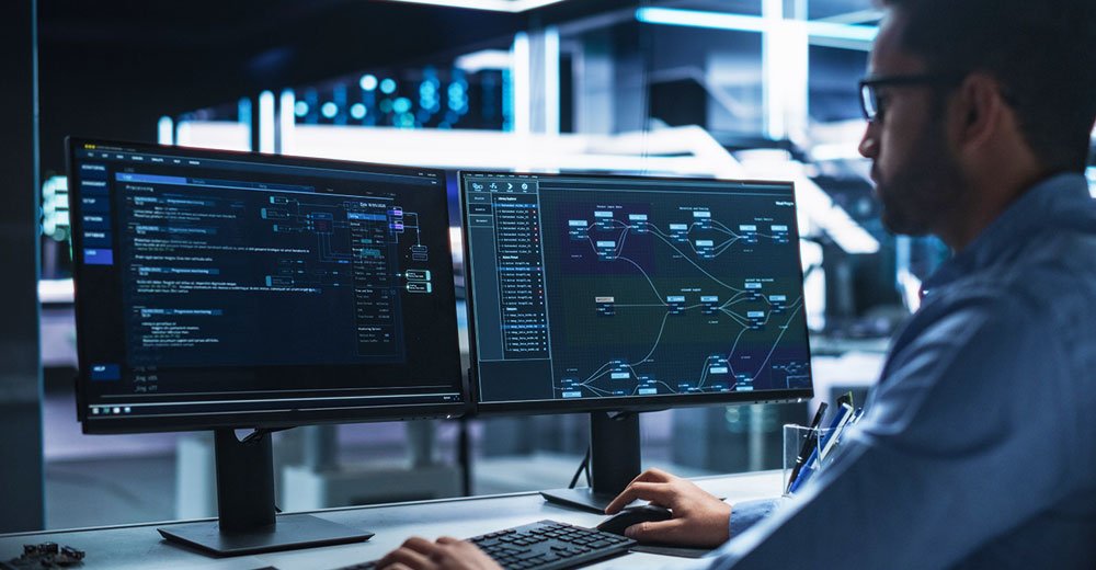 IT professional monitors AI analytics and cybersecurity dashboards, with hidden risks of shadow AI and unapproved SaaS tool usage in focus.