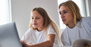 parent and teen using laptop