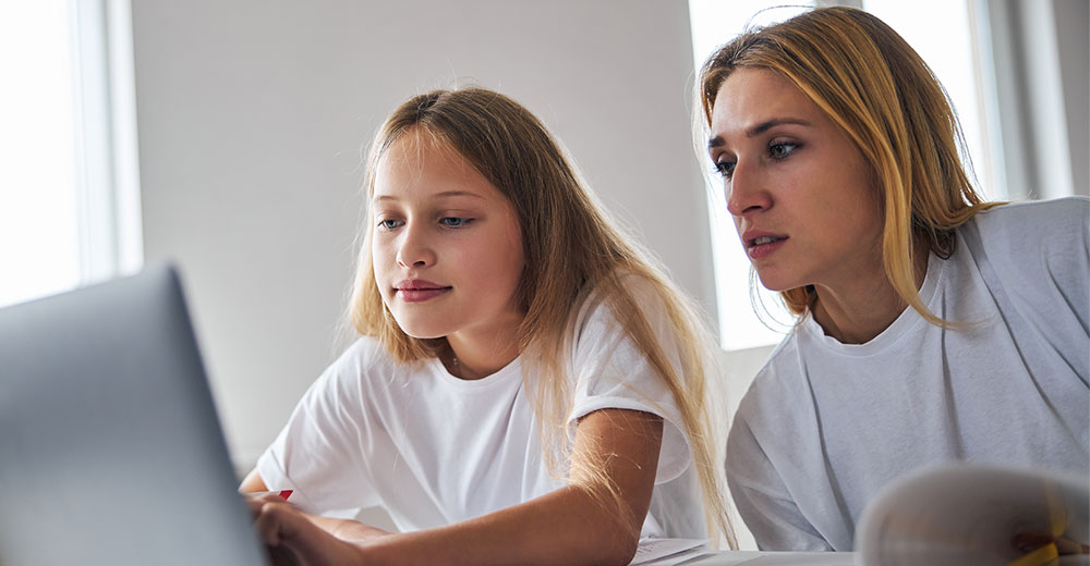 parent and teen using laptop