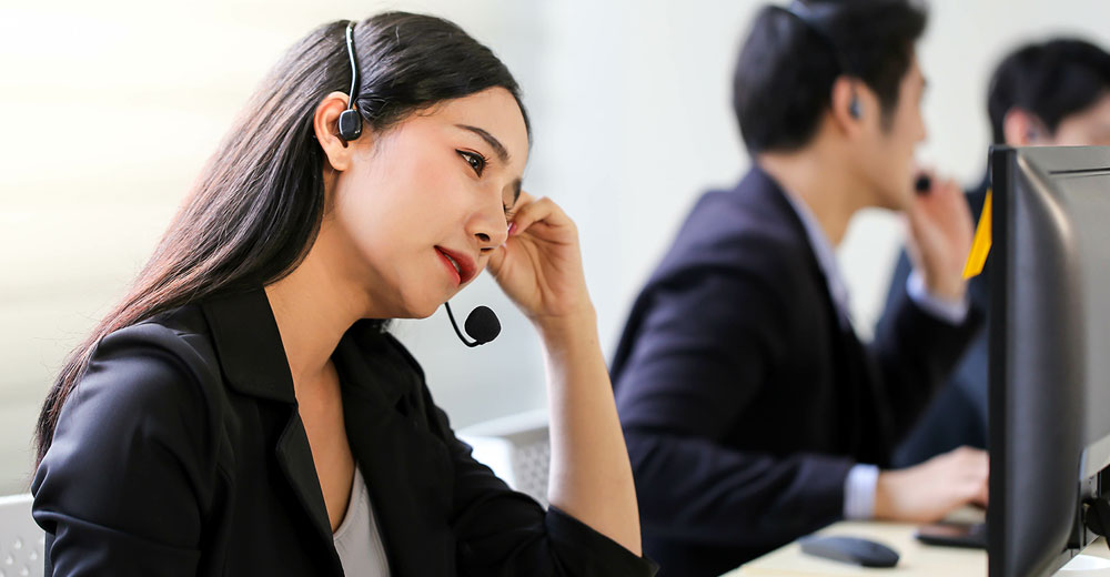 Help desk agent wearing a headset, appearing concerned during an identity verification call.
